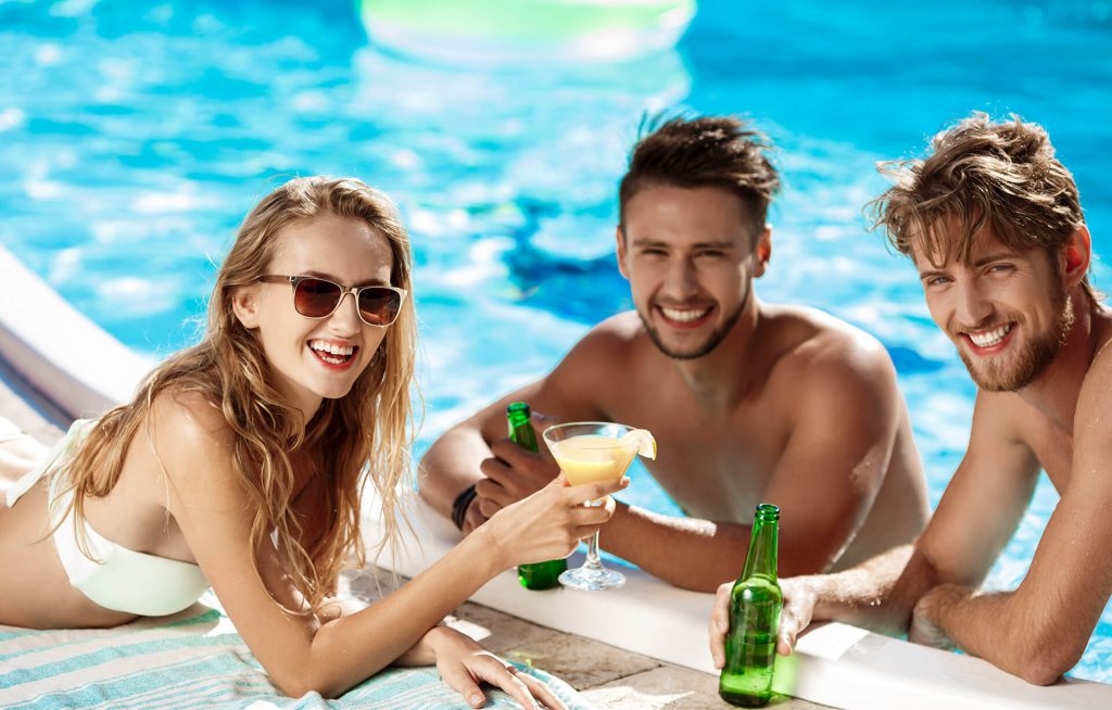 freunde-reden-lachen-trinken-cocktails-relax-swimming-pool